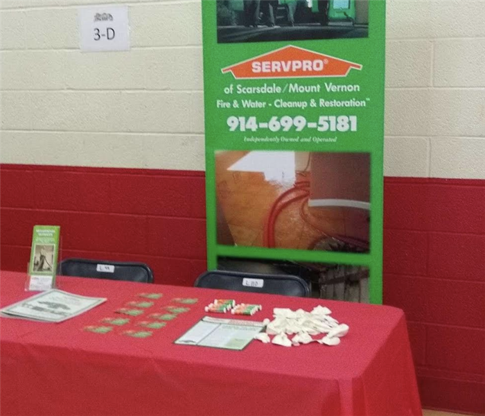 a green SERVPRO sign behind a red table