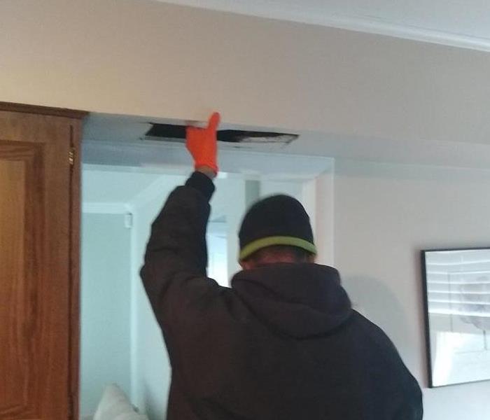 a man inspecting the ceiling of a home