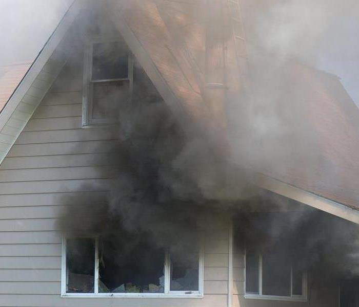 Black smoke flowing out of a house.