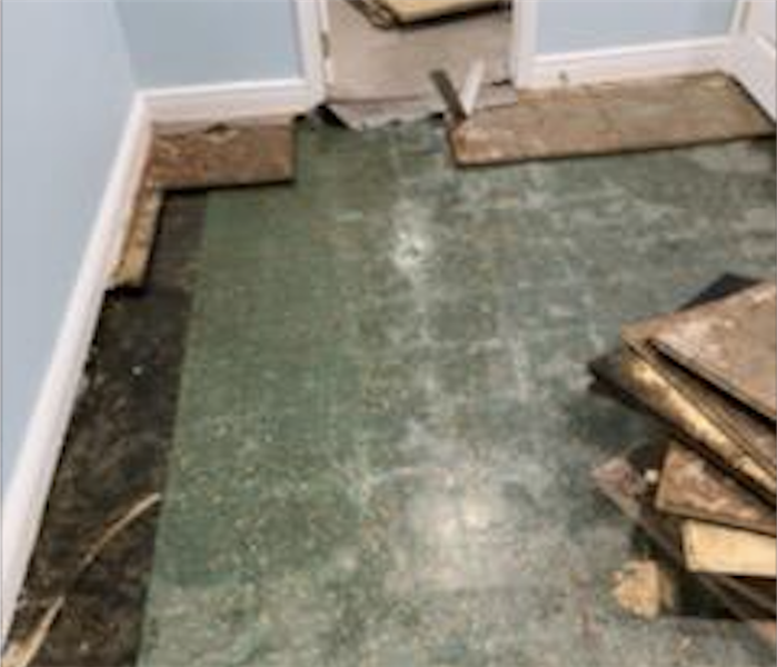 Partially demolished flooring in a small room.